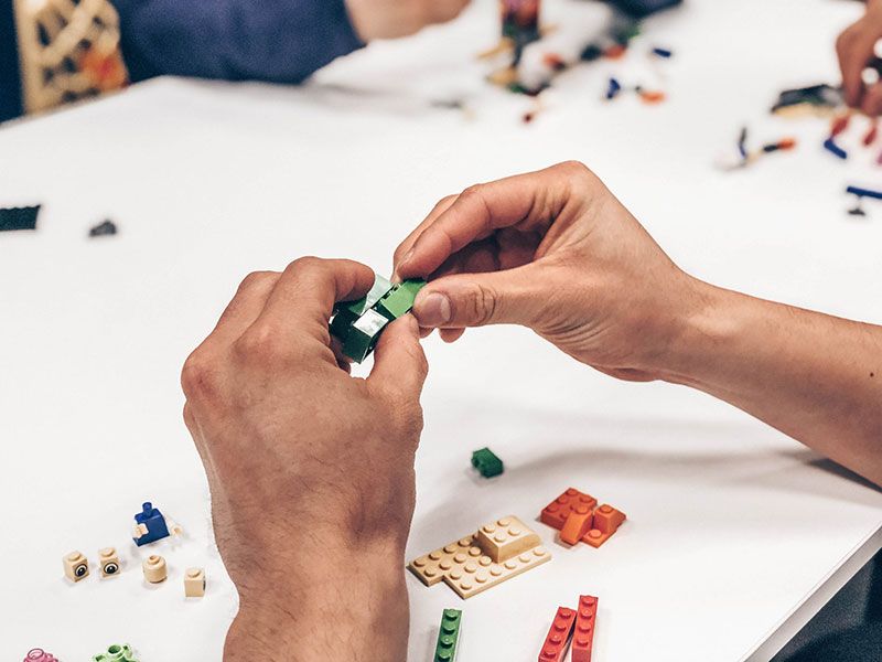 Hands assembling lego bricks